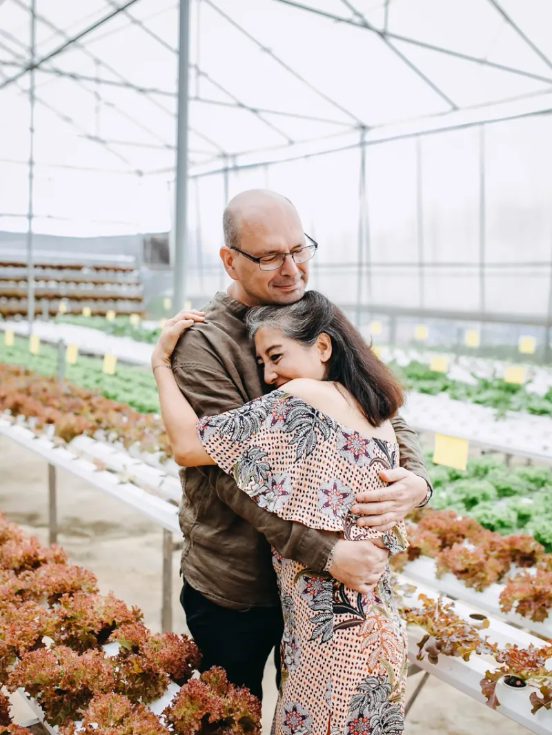 A couple hugging in a green house